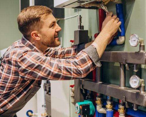 Young engineer adjusting autonomous heating Young engineer adjusting autonomous heating